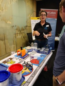 Person standing at a table filled with colorful teaching objects. 