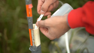 Person checking groundwater level at a temporary well.