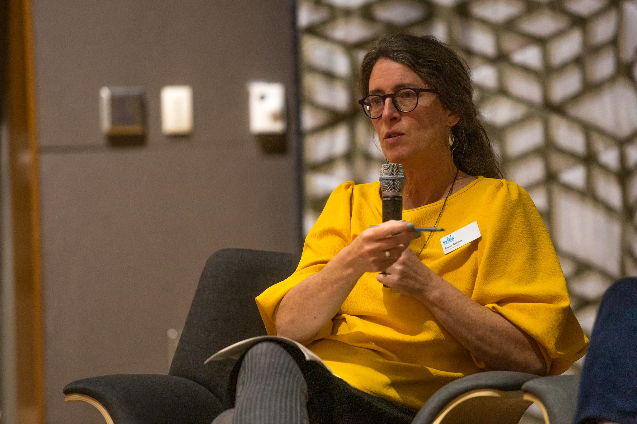 Person in a yellow shirt sitting in a chair.