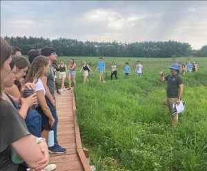 Group of people standing in a grassy area. 